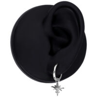 Orecchino nero con un ciondolo in argento a forma di piccolo ramo, su sfondo nero