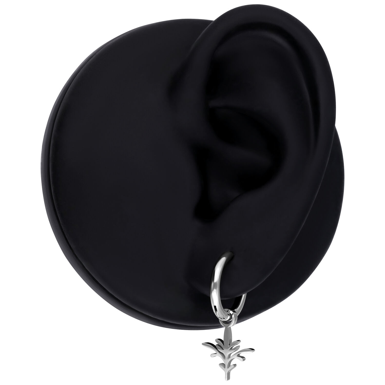 Orecchino nero con un ciondolo in argento a forma di piccolo ramo, su sfondo nero