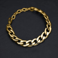 Bracciale Chunky dorato in acciaio chirurgico su sfondo nero