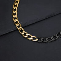 Collana chunky dorata e nera su sfondo nero