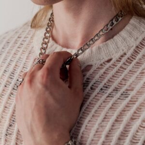 Persona con collana Chunky argento e maglione bianco a maglia