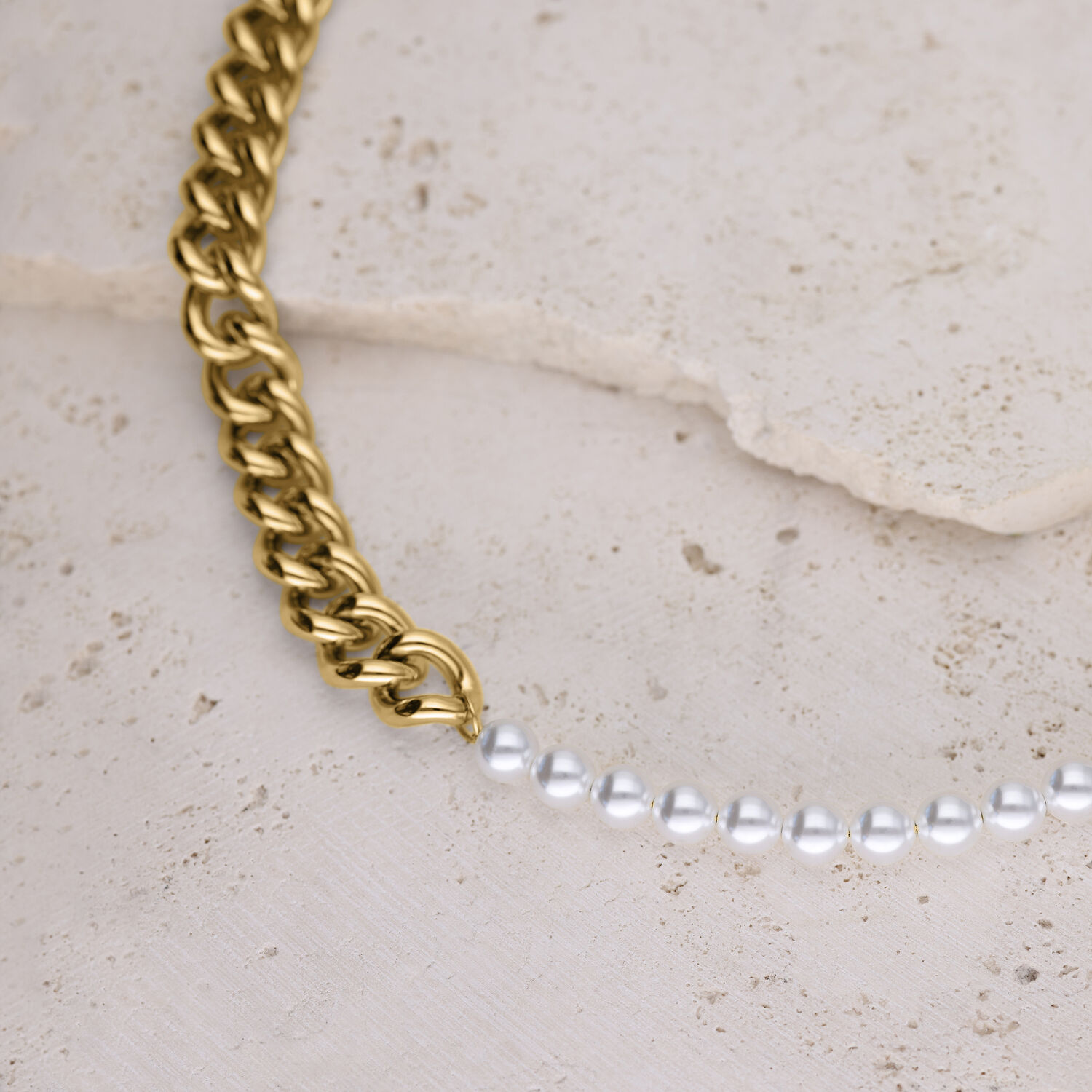 Collana dorata con grandi maglie e perle sintetiche bianche su pietra chiara