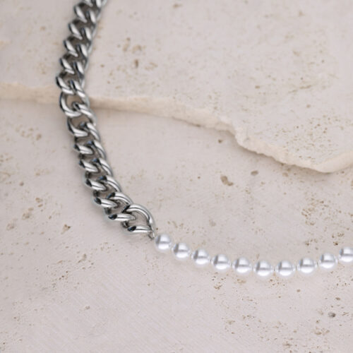 Collana a maglie d'argento combinata con perle sintetiche su sfondo di pietra chiara