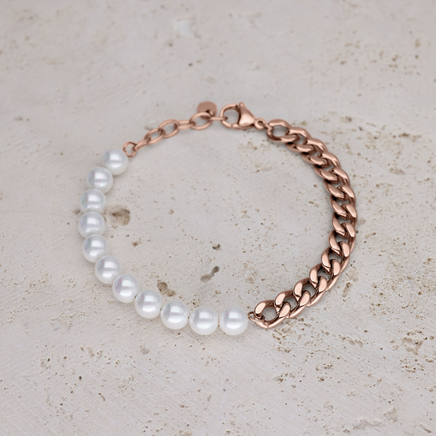 Bracciale con perle sintetiche e catena oro rosa su pietra chiara