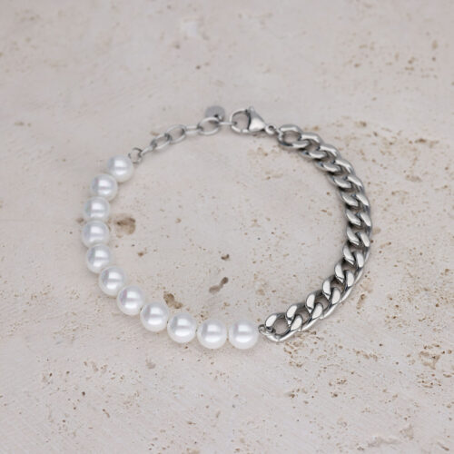 Bracciale con perle bianche e catena argentata su pietra chiara