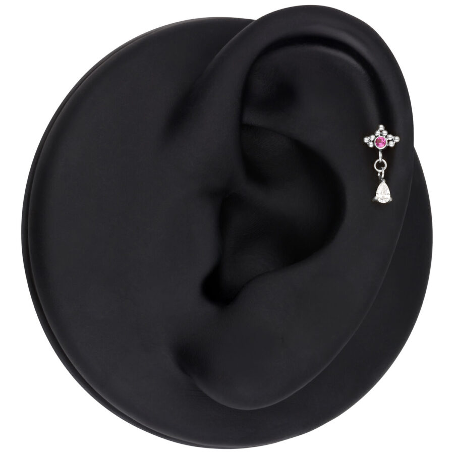 Piercing all'orecchio argento con cristallo rosso e pendente ovale, presentato su un modello di orecchio nero.
