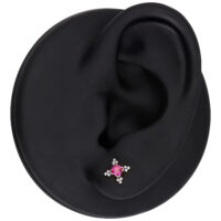 Modello di orecchio con accessorio per piercing in argento e cristallo rosso su sfondo nero