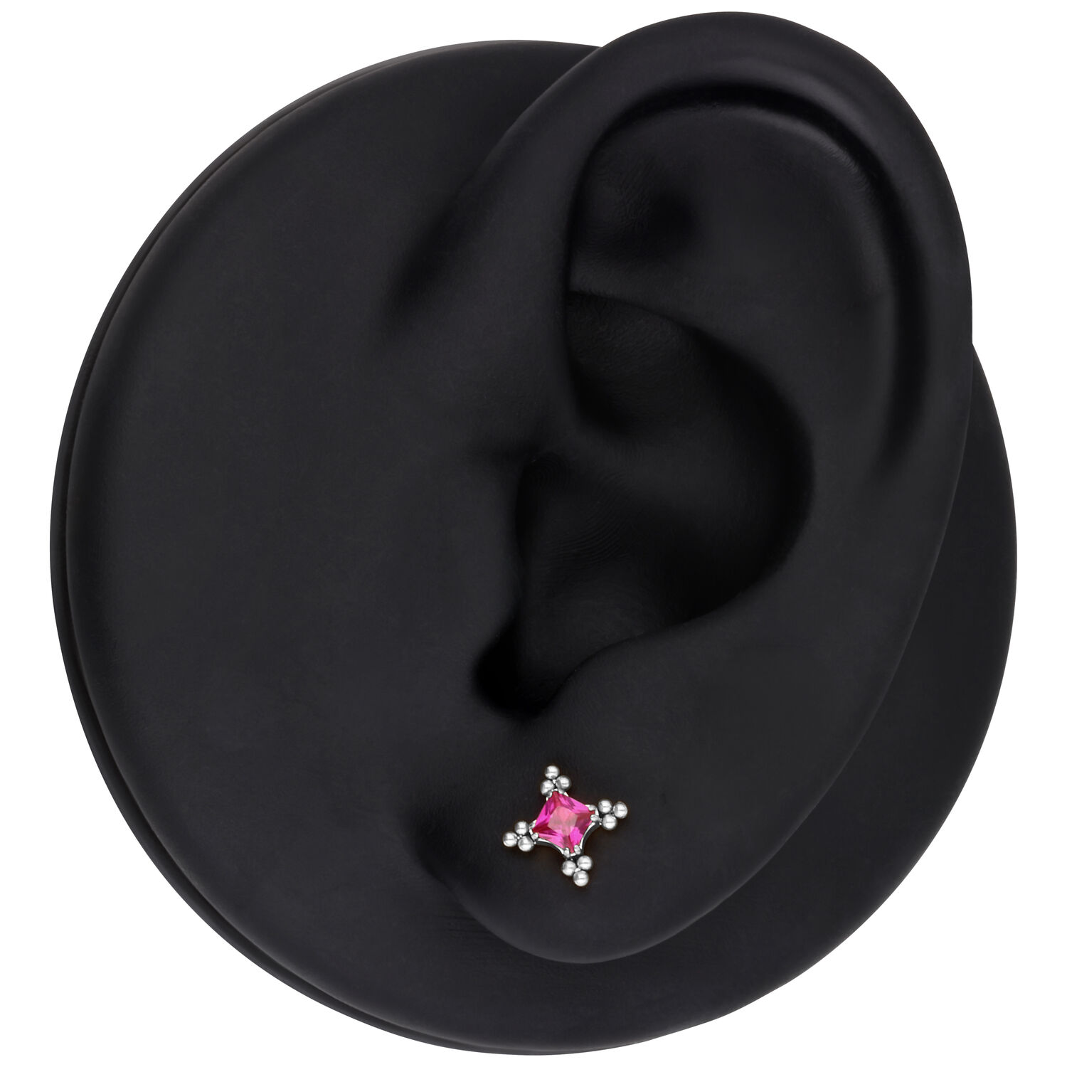 Modello di orecchio con accessorio per piercing in argento e cristallo rosso su sfondo nero