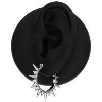 Orecchini Spiked in argento su un modello di orecchio nero su sfondo bianco