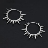 Due orecchini a spillo argentati in acciaio chirurgico su sfondo nero