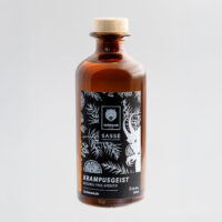 Wildcat Gin analcolico 0,35L bottiglia Bottiglia di vetro marrone con etichetta nera, motivi botanici, sfondo grigio