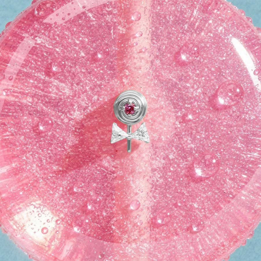 Punta Lollipop argento con pietra rosa su sfondo rosa scintillante