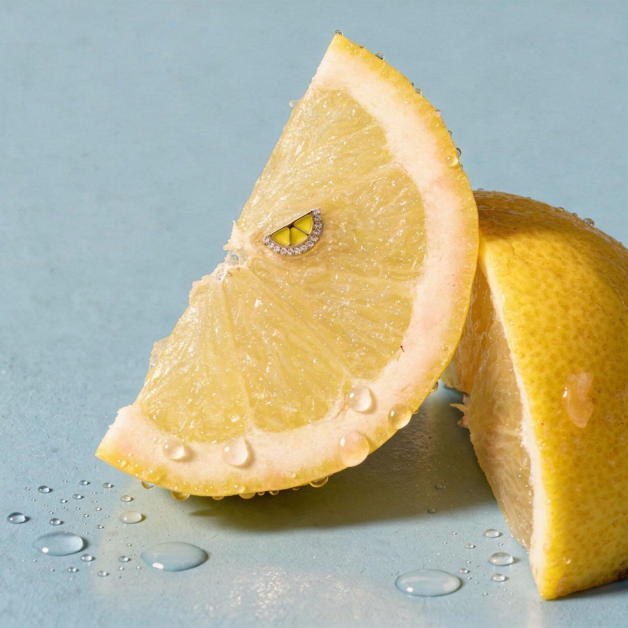 Due fette di limone su sfondo blu, una con piccolo attacco dorato