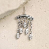 Accessorio argento con cinque gocce cristalline su catene su sfondo chiaro