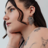 Donna con inserti piercing in argento all'orecchio, di profilo