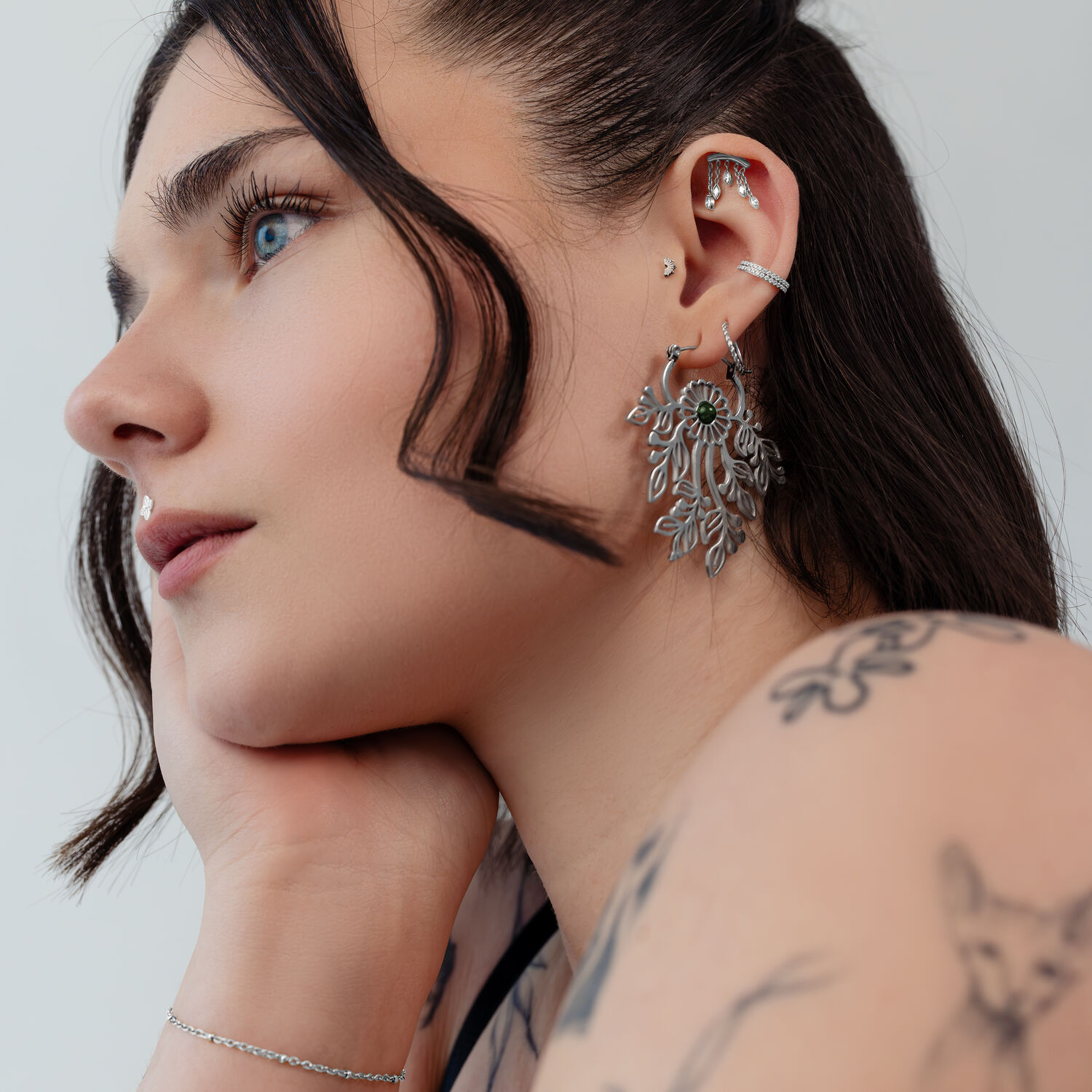 Donna con inserti piercing in argento all'orecchio, di profilo