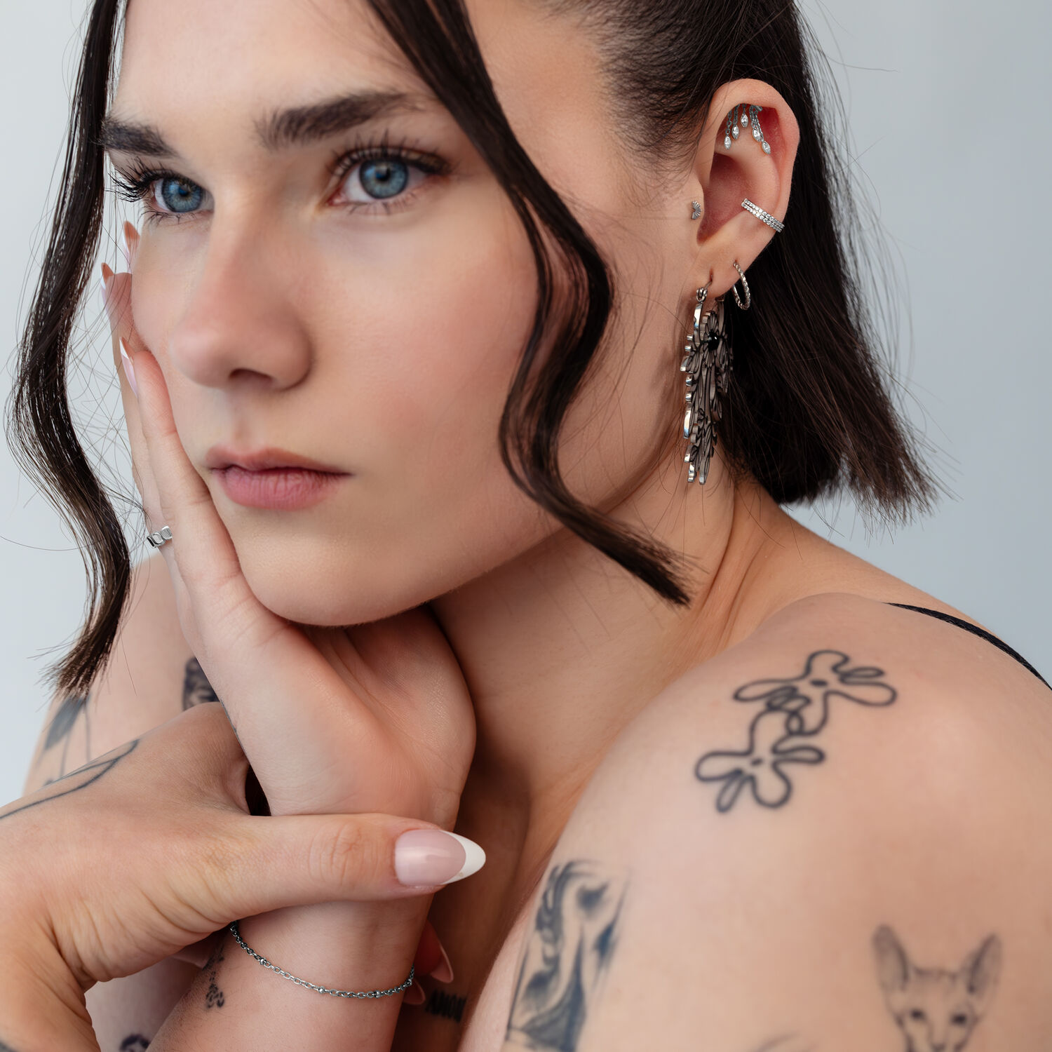 Donna con diversi piercing all'orecchio, incluso un accessorio Helix argento, primo piano