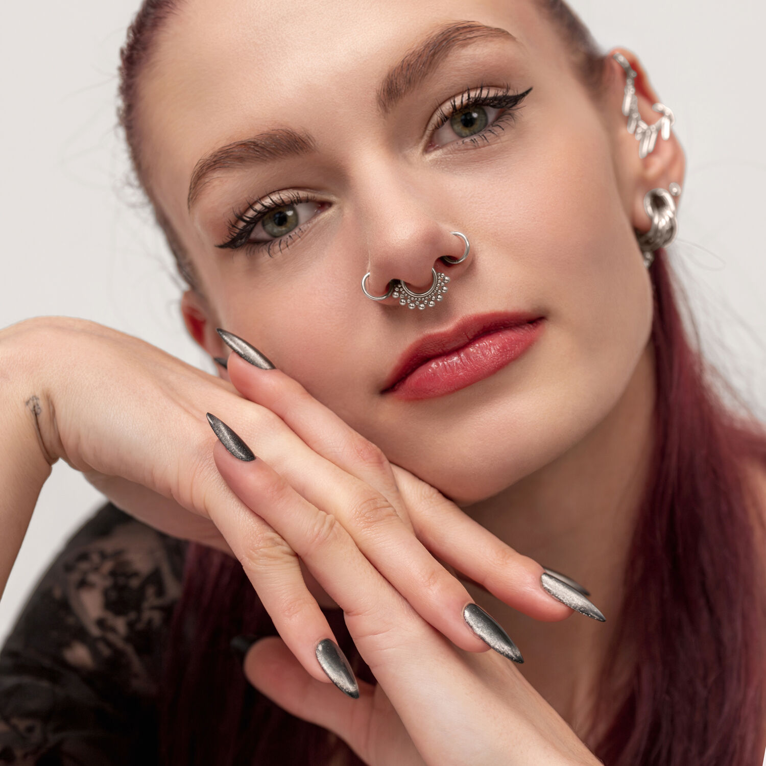 Elegante Clicker per Setto con Sfere Decorative Donna con capelli rossi indossa un Clicker per setto in argento con sfere decorative