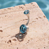 Piercing all'ombelico con cristalli turchesi e catena su pietra
