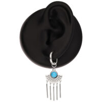 Orecchini a cerchio d'argento con turchese e ciondoli Orecchino a cerchio d'argento con pietra turchese e barrette pendenti su un modello di orecchio nero