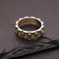 Anello argento e oro in acciaio chirurgico su pietra scura