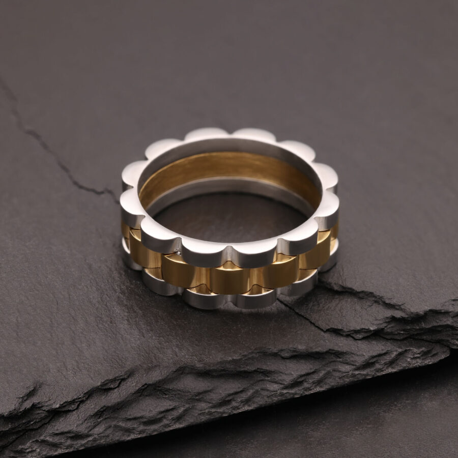 Anello argento e oro in acciaio chirurgico su pietra scura