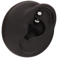 Micro Bananabell in argento Push Fit per l'orecchio Micro Bananabell in argento su modello di orecchio nero, un fiore di cristallo in alto e una fila di cristalli curvi in basso