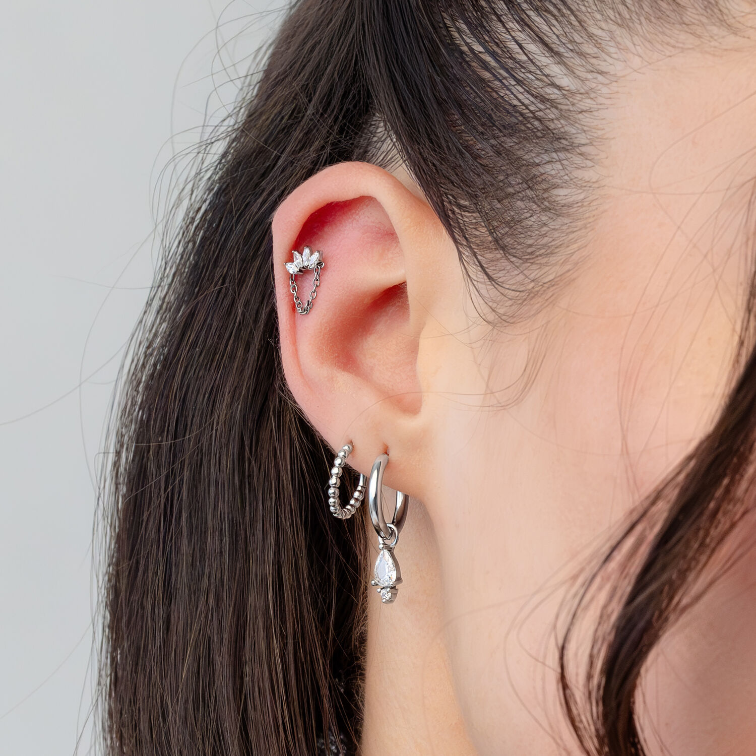 Punta piercing a corona di cristallo argento Orecchio con diversi piercing argento, incluso un'applique a corona di cristallo