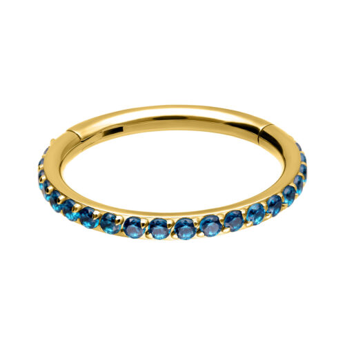 Clicker piercing dorato con cristalli turchesi, disposti intorno su sfondo bianco.