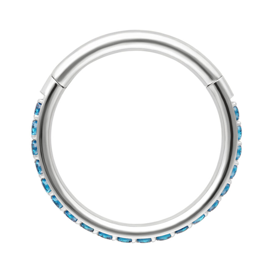 Clicker rotondo in argento con cristalli turchesi lungo il bordo, su sfondo bianco