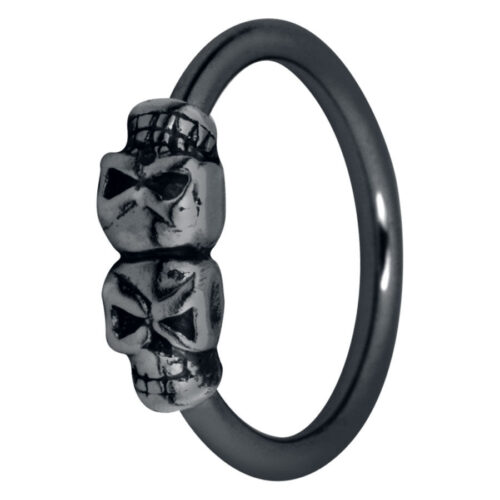 Anello nero con due piccoli teschi, in acciaio chirurgico, su sfondo bianco