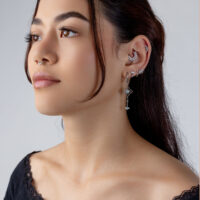 Orecchino in Cristallo Argento con Design Tiara Donna con diversi piercing d'argento all'orecchio, incluso un attacco a tiara
