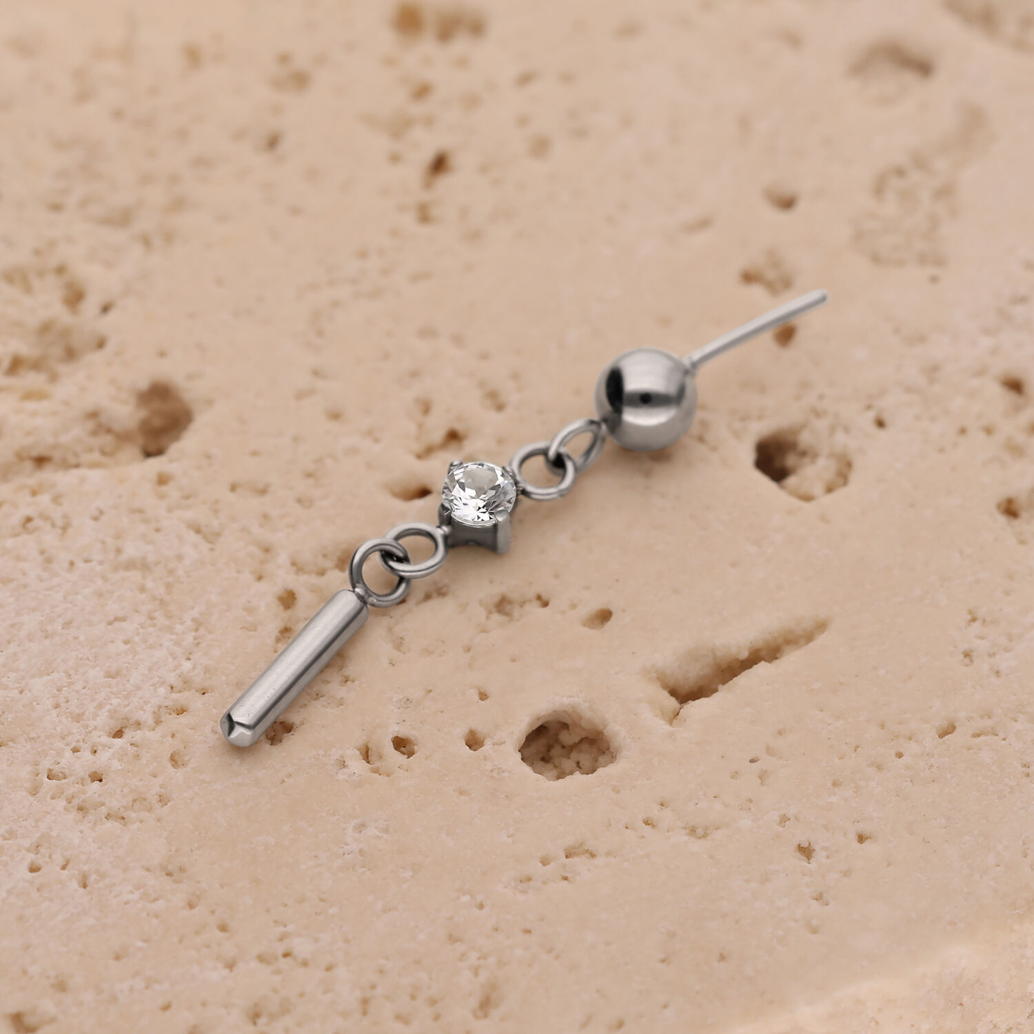 Punta per piercing argento con cristallo rotondo e piccolo stelo su struttura beige