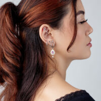 Accessorio per piercing all'orecchio in argento con cristallo Donna con diversi orecchini in argento e un accessorio con cristallo nell'orecchio, vista laterale