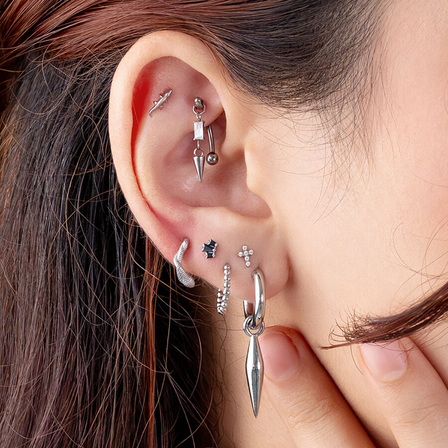 Orecchio con diversi piercing in argento e nero, Rook e Helix