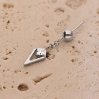 Inserto per piercing in argento con cristallo su superficie beige strutturata