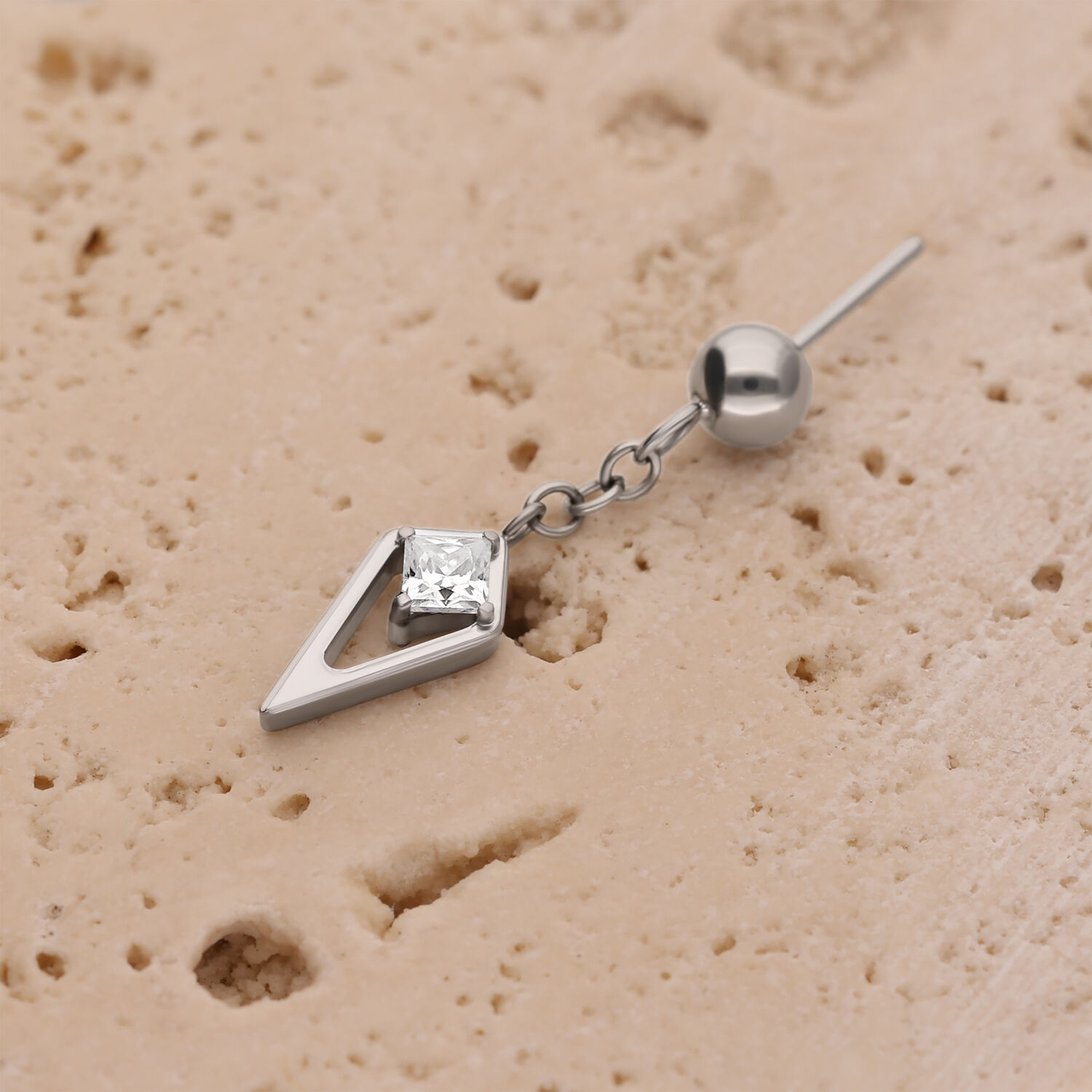 Inserto per piercing in argento con cristallo su superficie beige strutturata