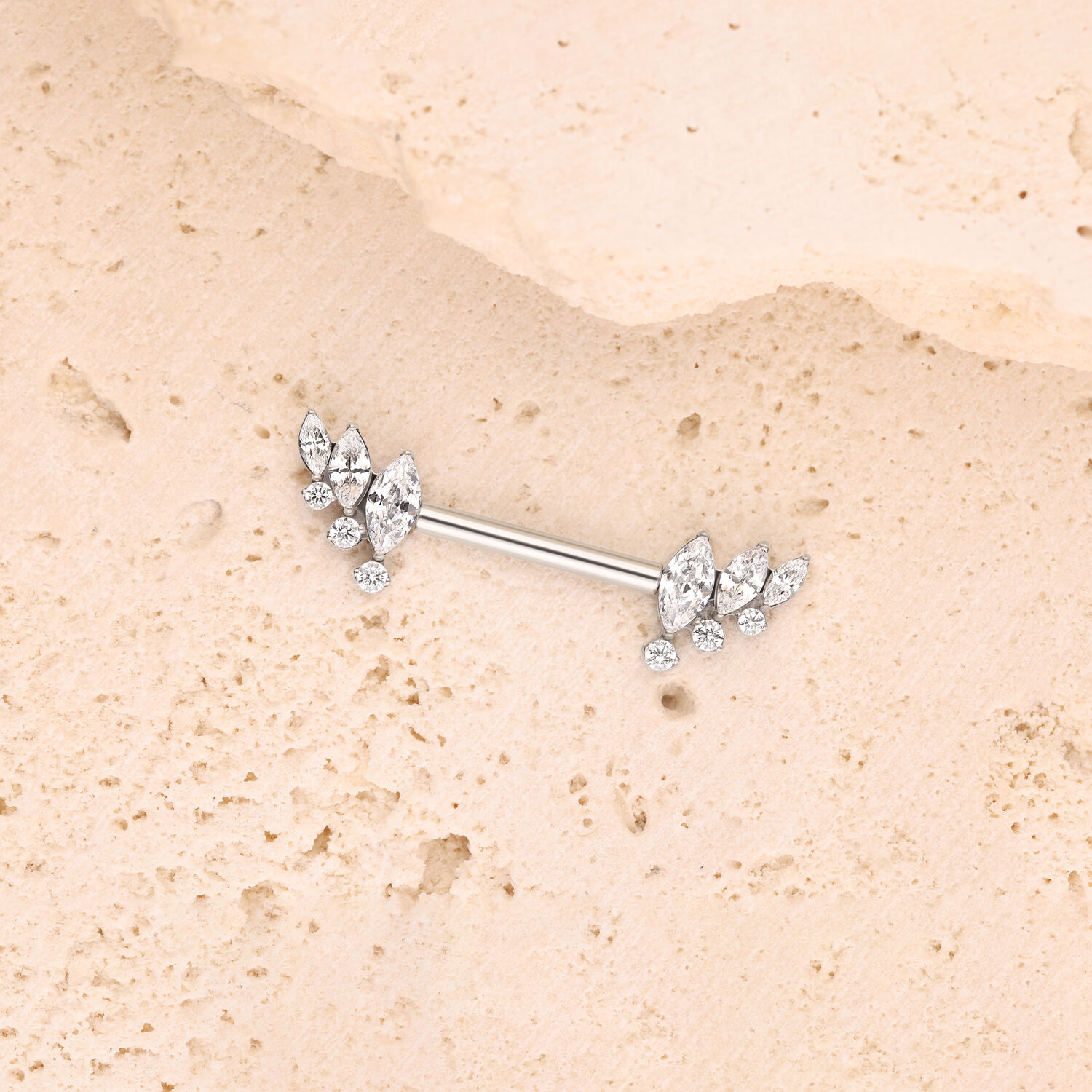 Barbell d'argento con ali di cristallo Barbell d'argento con ali di cristallo su superficie di pietra beige