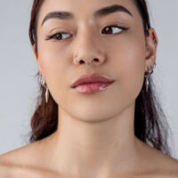 Clicker Piercing a Goccia d'Argento Donna con clicker a goccia d'argento nel septum, sfondo neutro