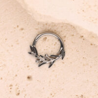 Clicker per Setto Olive Branch Argento Clicker per setto in argento a forma di ramo d'olivo su sfondo color sabbia